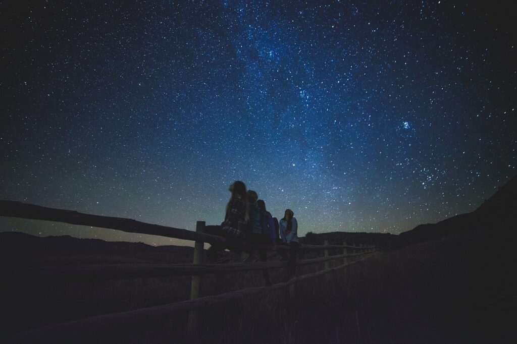 Alcune ragazze sono sedute insieme ed osservano le stelle